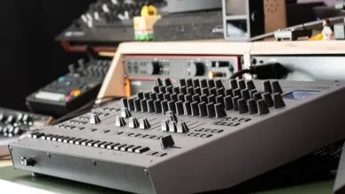 Roland TR-1000 Rhythm Creator with knobs and sliders in a studio setting.