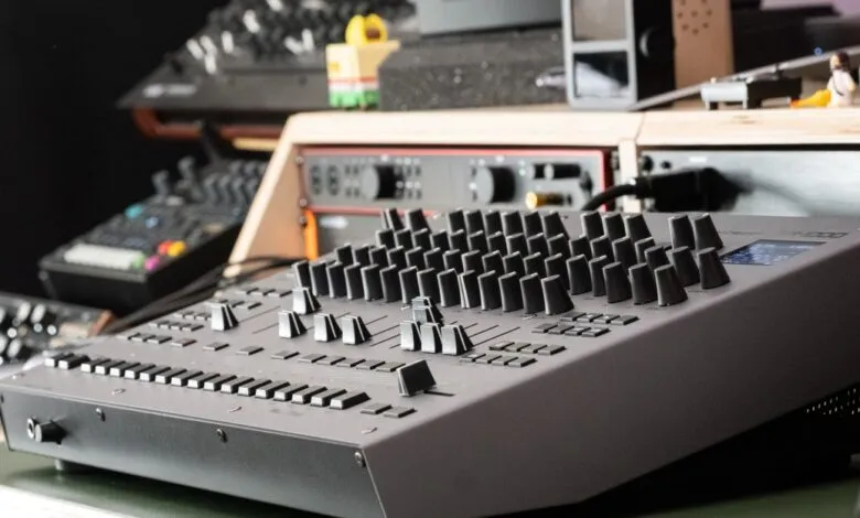 Roland TR-1000 Rhythm Creator with knobs and sliders in a studio setting.