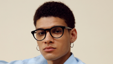 Portrait of a young man with glasses and hoop earrings.