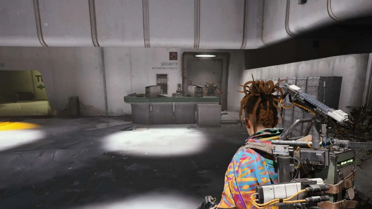 Character with dreadlocks stands in a sterile, restricted access area.