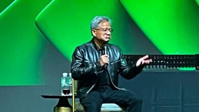 Jensen Huang, CEO of NVIDIA, speaking on stage with a green background.