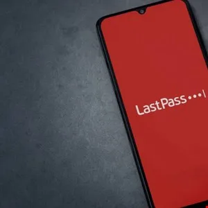 Smartphone displays LastPass app logo on a red screen against a dark background.