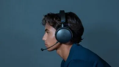 Profile of person wearing black gaming headset with microphone.