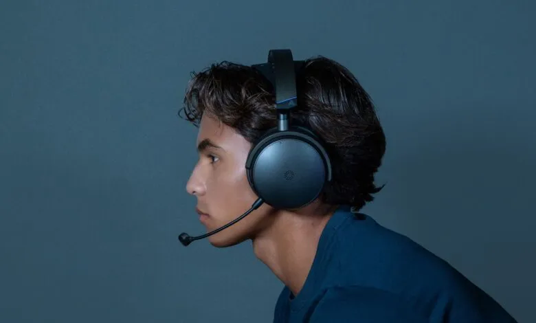 Profile of person wearing black gaming headset with microphone.
