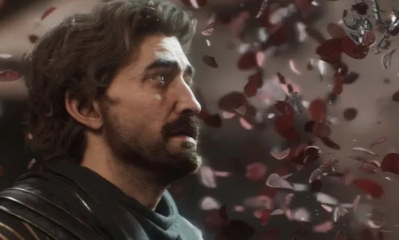 Man with dark hair and mustache looks up as rose petals fall.