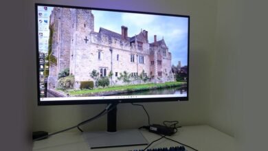 Computer monitor displaying a castle scene on a white desk.
