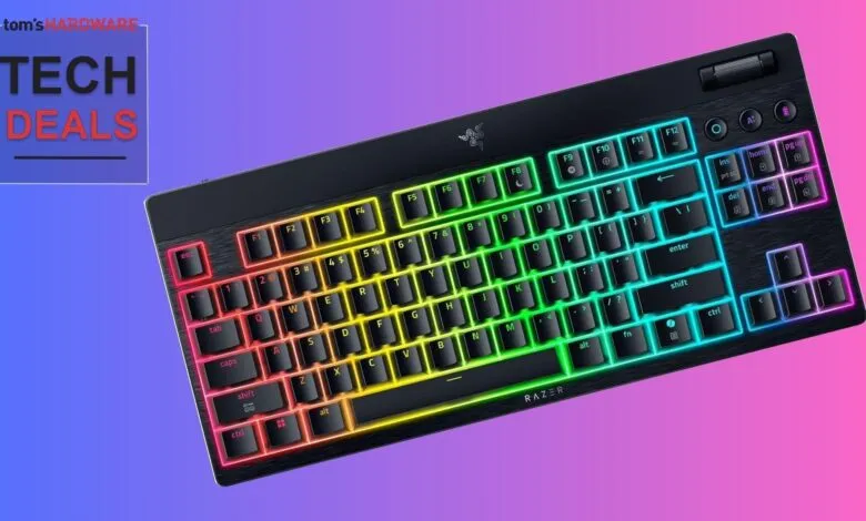 Razer keyboard with rainbow RGB lighting on a colorful background.