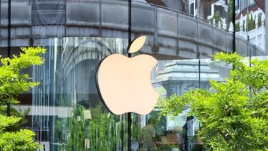 Apple store exterior with large logo and building reflections.