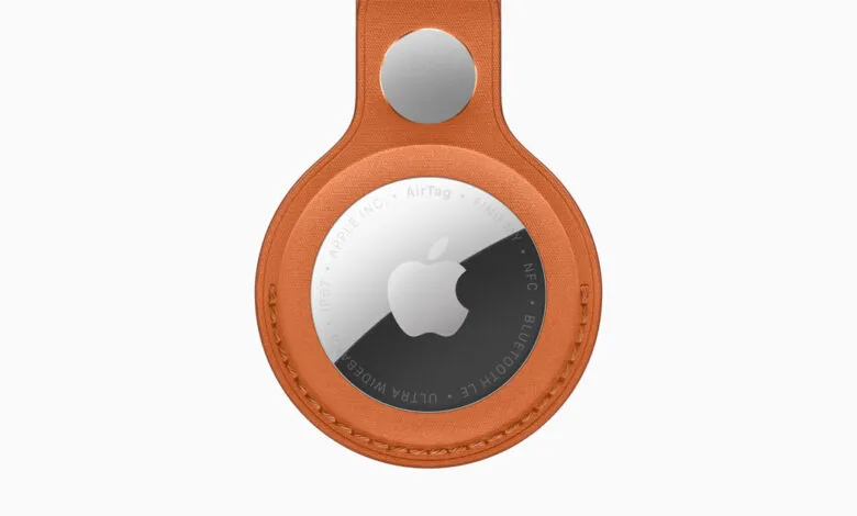 Apple AirTag in orange FineWoven Key Ring, close-up view.