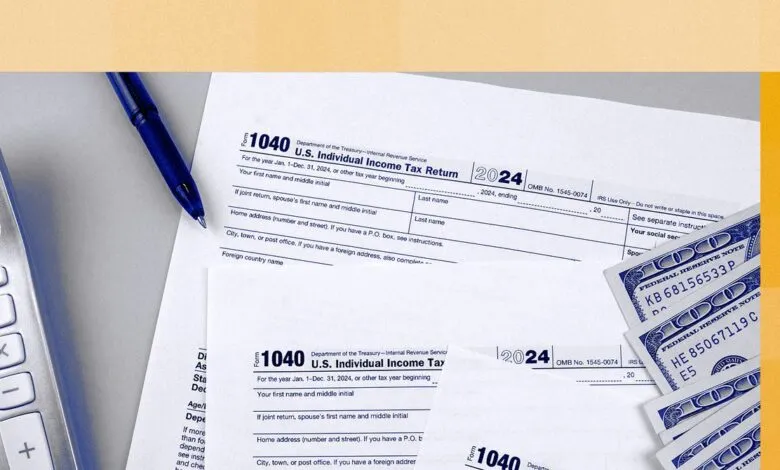 Tax form 1040 with pen, calculator, and hundred dollar bills.