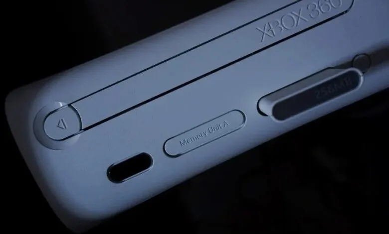 Close-up of a white Xbox 360 console showing the power button and memory unit slots.