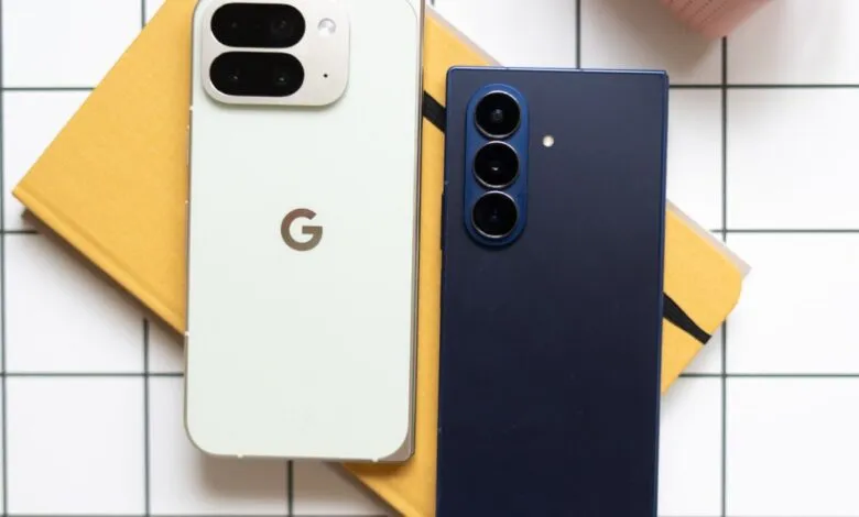 Two smartphones resting on a yellow notebook on a white tiled surface.
