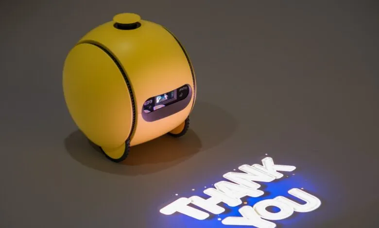 Yellow robot projecting 'Thank You' message on floor.