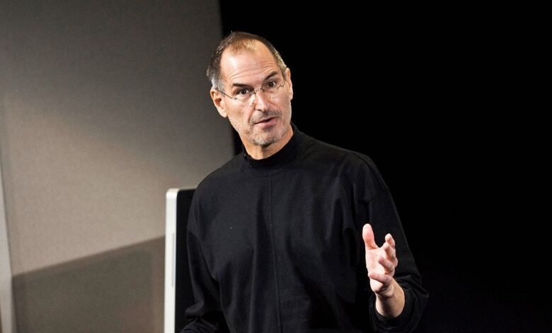 Steve Jobs in black turtleneck gesturing during a presentation.