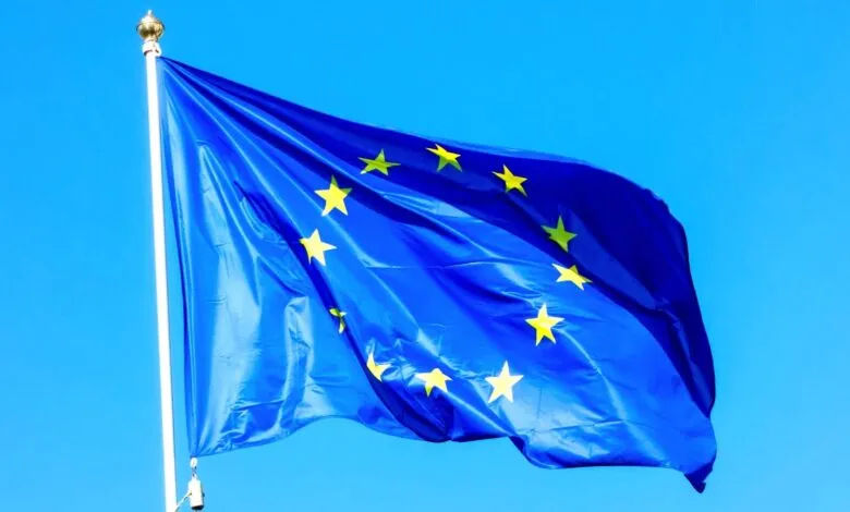 European Union flag waving against a clear blue sky.