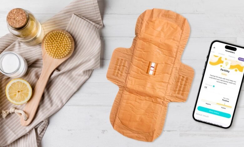 Fertility test pad and app showing positive result, with wellness items.