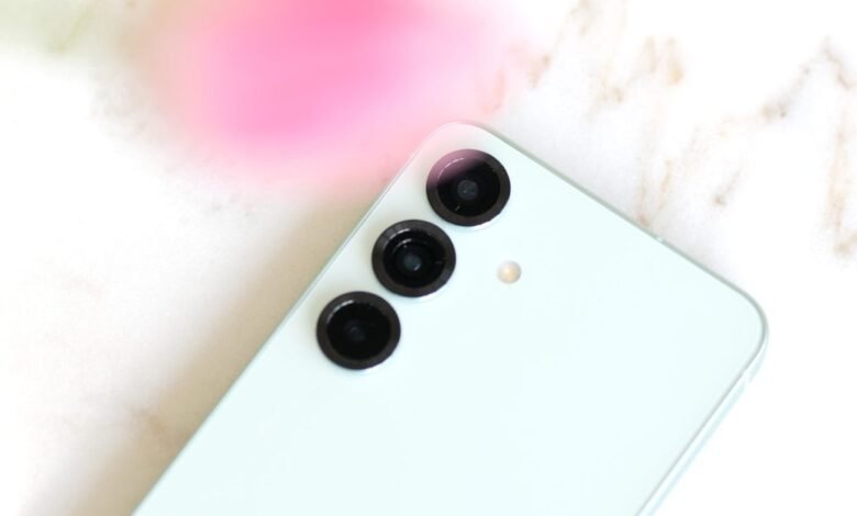 Close-up of a light blue smartphone with a triple-lens camera system.