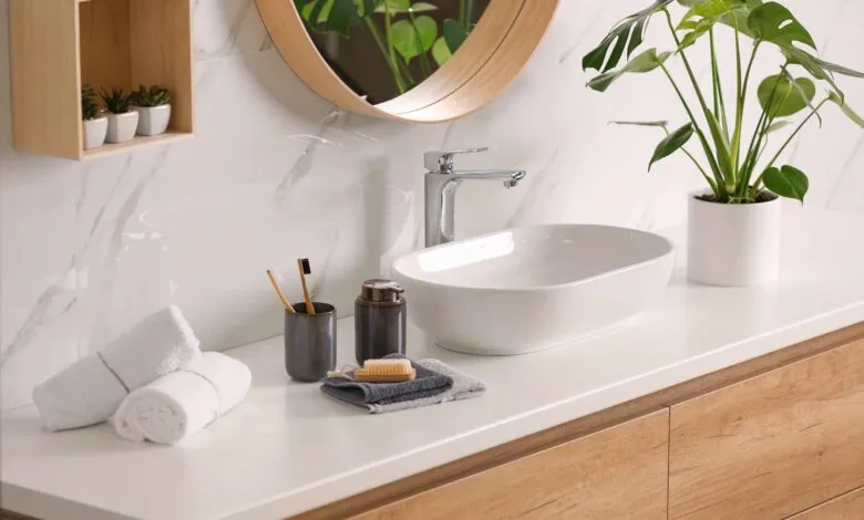Modern bathroom vanity with white countertop, oval sink, and wood accents.