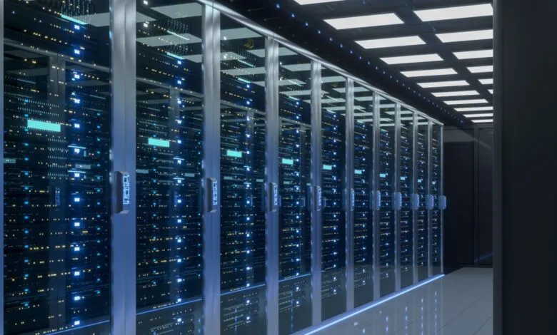 Server room with rows of computer racks and blinking lights.