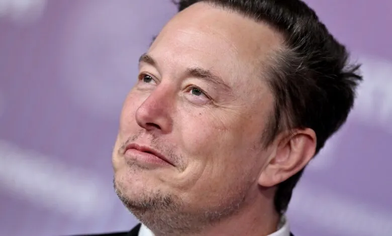 Close-up of Elon Musk looking upwards with a thoughtful expression.
