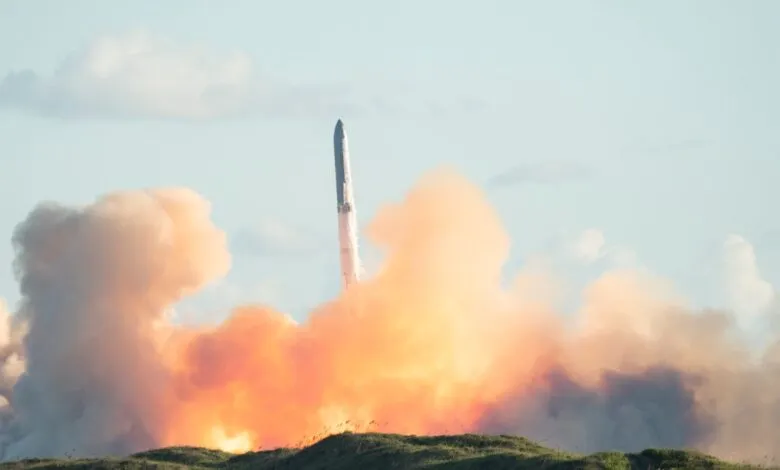 Rocket ascends through fiery cloud during launch sequence.