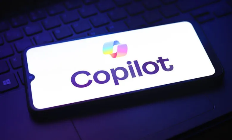 Smartphone displaying Microsoft Copilot logo on a laptop keyboard.
