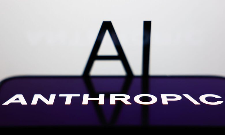 Anthropic logo on phone screen with 'AI' in background.