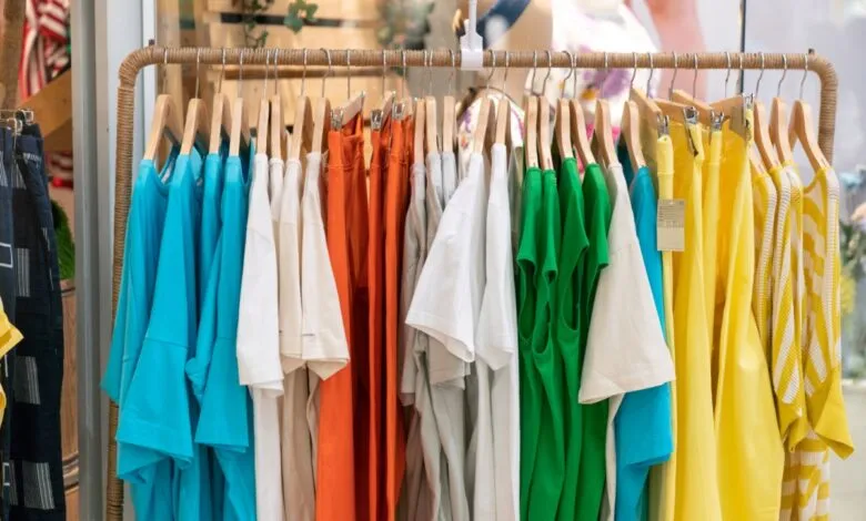 Colorful clothing rack with shirts in blue, white, orange, green, and yellow.