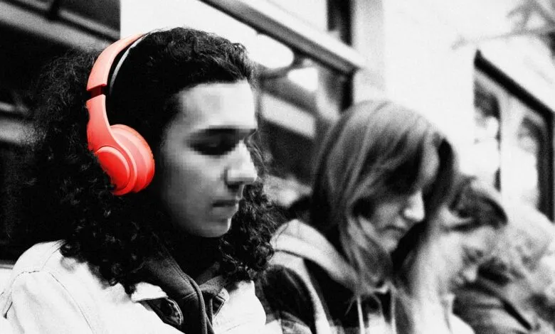 Person wearing bright red headphones on public transport, monochrome image.