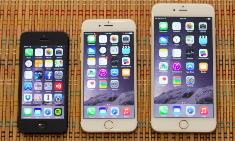 Three iPhones of different sizes are displayed on a textured surface.