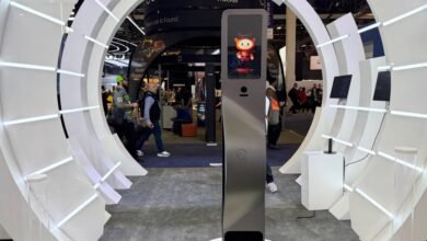 Trade show booth with circular white display and interactive kiosk.