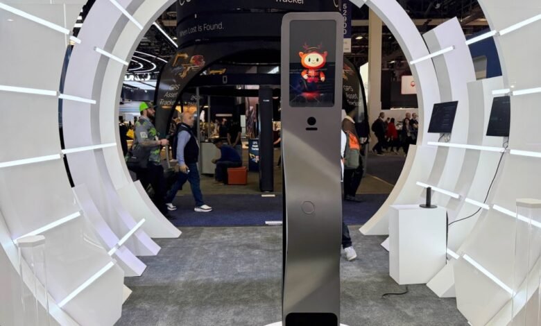 Trade show booth with circular white display and interactive kiosk.