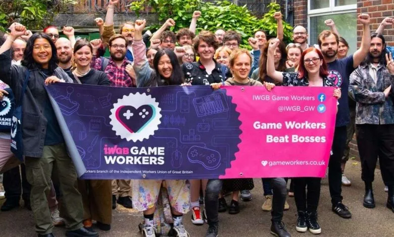 Group of IWGB Game Workers holding banner with raised fists in solidarity.