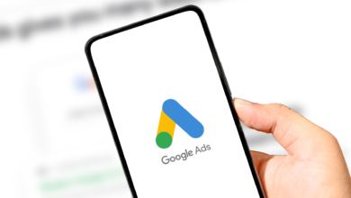 Hand holding phone displaying the Google Ads logo.