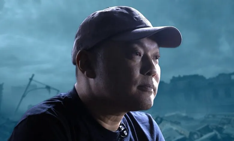 Man in cap with destroyed city backdrop, looking thoughtful.