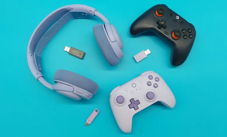 Gaming setup with lavender headphones, black and lavender controllers, and USB dongles.