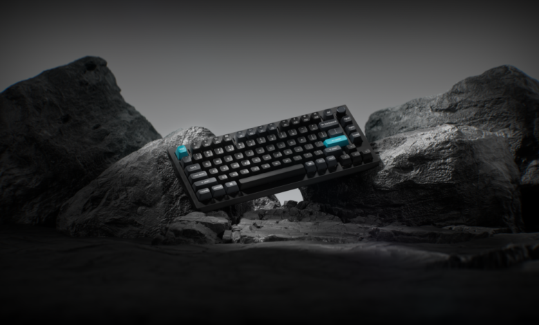 Black Keychron Q1 Ultra keyboard with blue accents on rocky terrain.