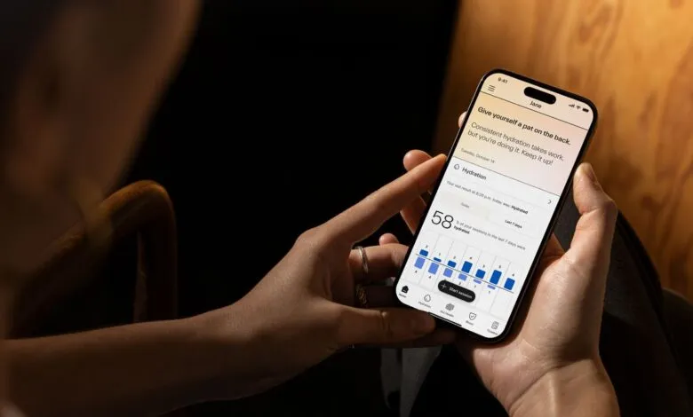 Person holds phone displaying hydration tracking app with positive encouragement message.