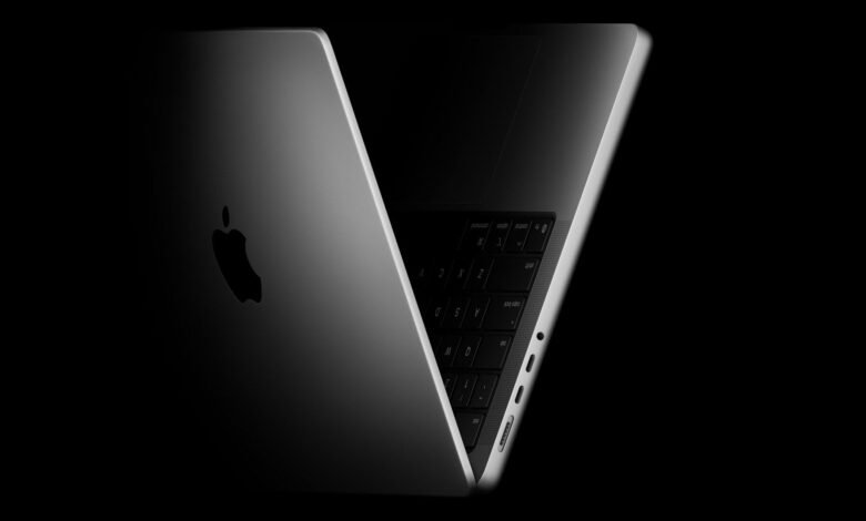 Sleek silver MacBook Pro laptop with Apple logo against a dark background.