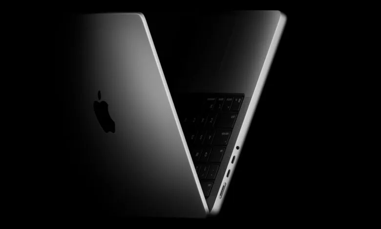 Sleek silver MacBook Pro laptop with Apple logo against a dark background.