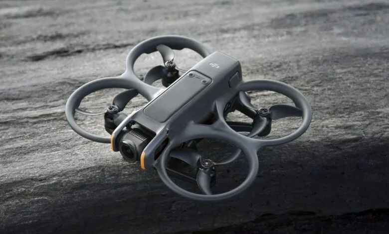 Gray DJI Avata drone rests on a textured gray surface.