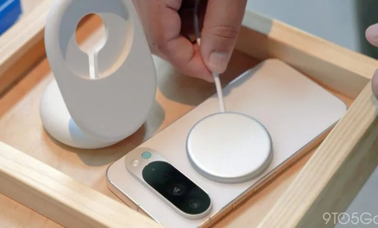 Pixel phone charging wirelessly with puck and stand in wooden tray.
