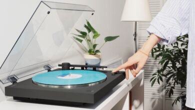 Person starting a Sony turntable with a blue vinyl record.