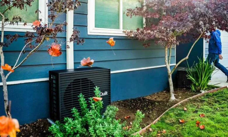 Black Quilt outdoor unit sits beside a blue house with falling leaves.