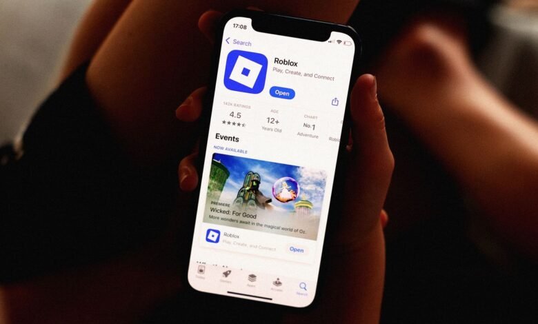 Person holding phone showing Roblox app in the app store.