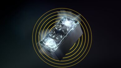 Illuminated LEGO brick with golden concentric circles on dark background.