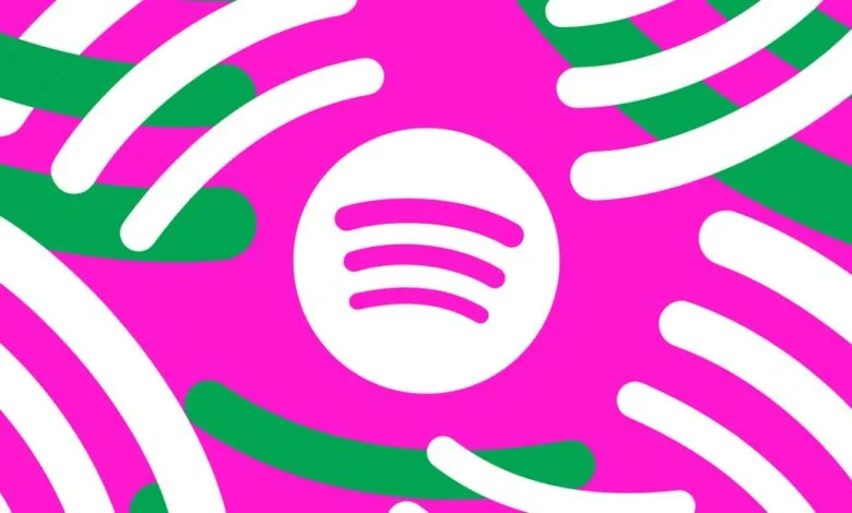 Spotify logo on vibrant pink and green abstract background.