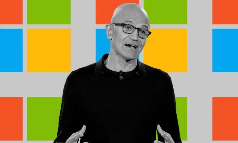 Satya Nadella, Microsoft CEO, speaks in front of colorful Windows logo.