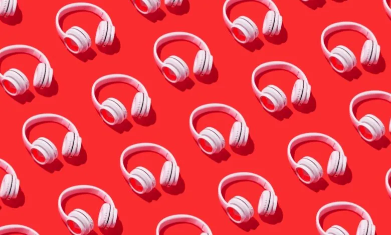 Pattern of white headphones arranged on a bright red background.