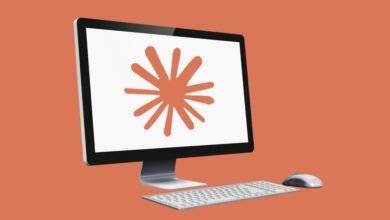 Computer with orange starburst on screen, keyboard and mouse.